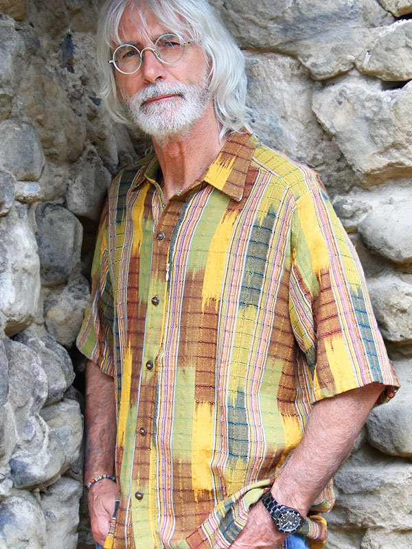 Camicie uomo estive: un uomo con barba e capelli bianchi indossa una camicia estiva colorata a maniche corte