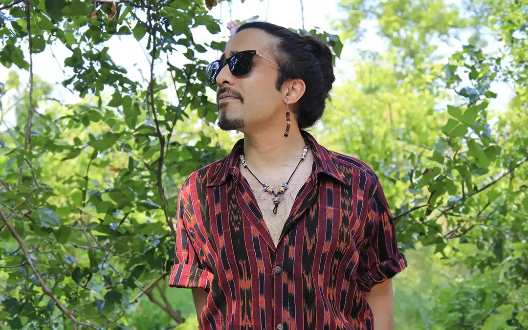 un giovane uomo con camicia stile boho di colore rosso con motivo geometrico nero